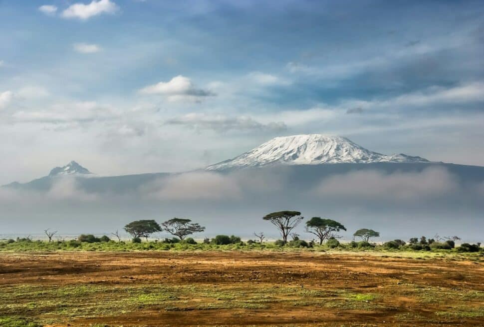 Kilimanjaro routes – Mount Kilimanjaro's snow-capped peak above the clouds, seen from Amboseli National Park, Kenya