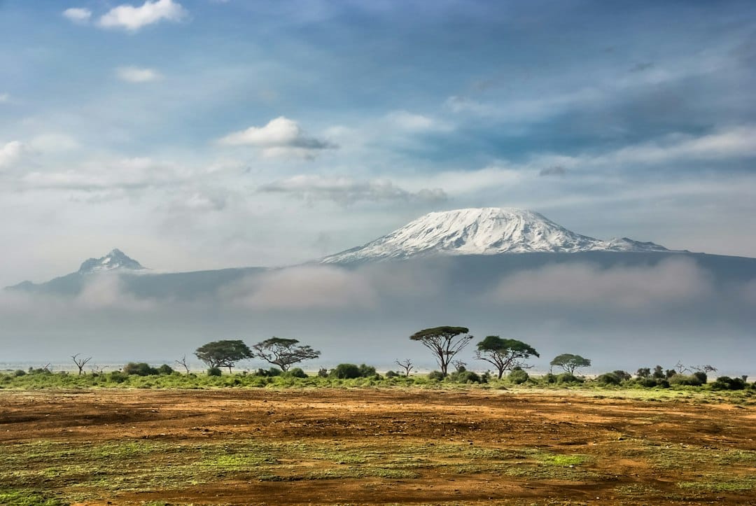 Kilimanjaro routes – Mount Kilimanjaro's snow-capped peak above the clouds, seen from Amboseli National Park, Kenya